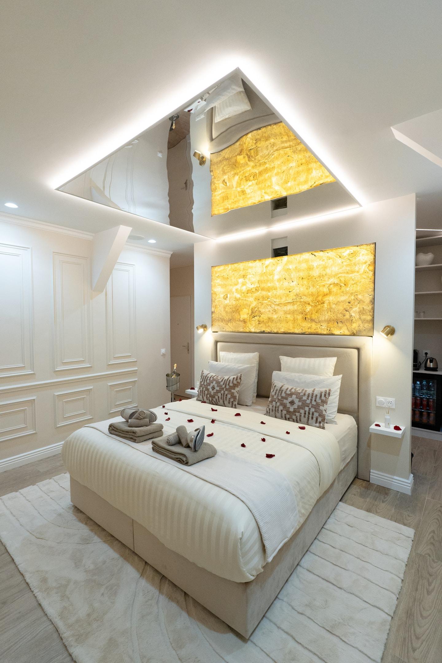 The bedroom with its backlit gold headboard and white mouldings