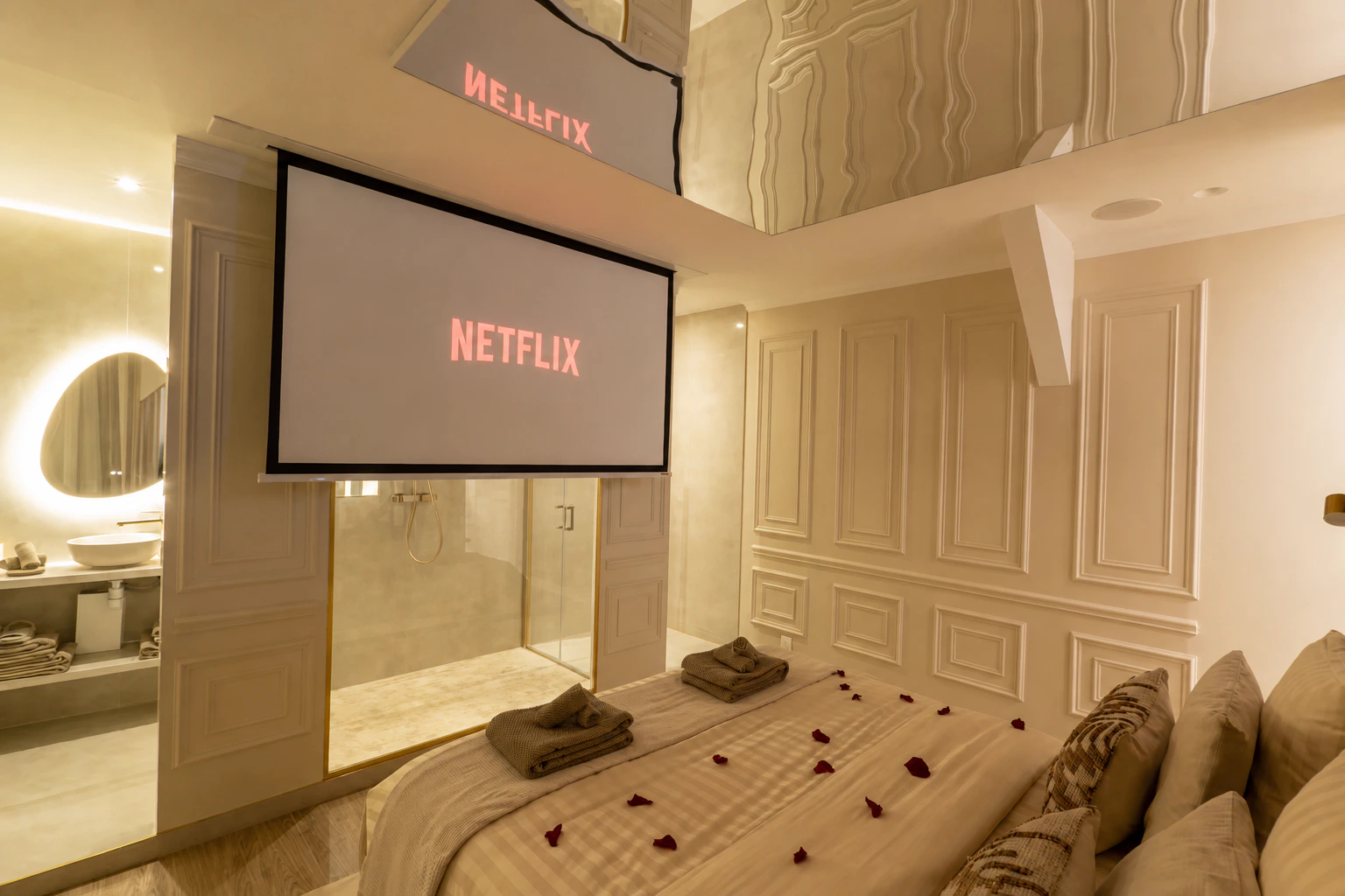Stellar Suite home cinema with a large projection screen facing the bed