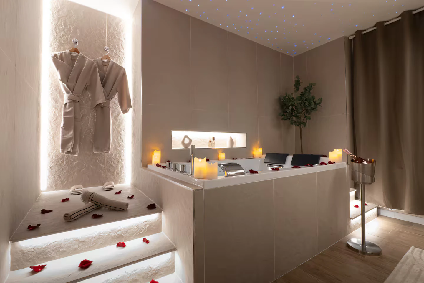 The Stellar Suite jacuzzi, surrounded by candles, rose petals and bathrobes